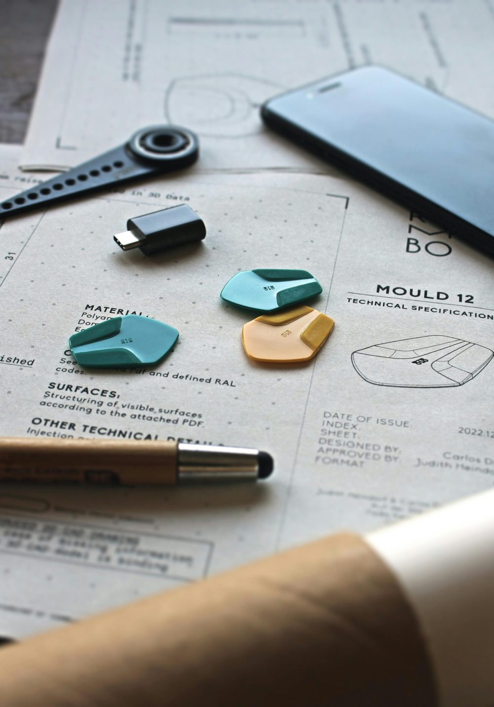Close-up of a creative workspace featuring schematics, guitar picks, and design tools.